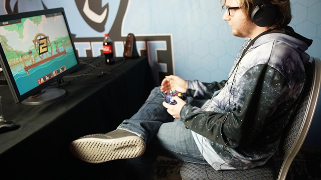 man-sitting-and-playing-video-game-using-control-pad